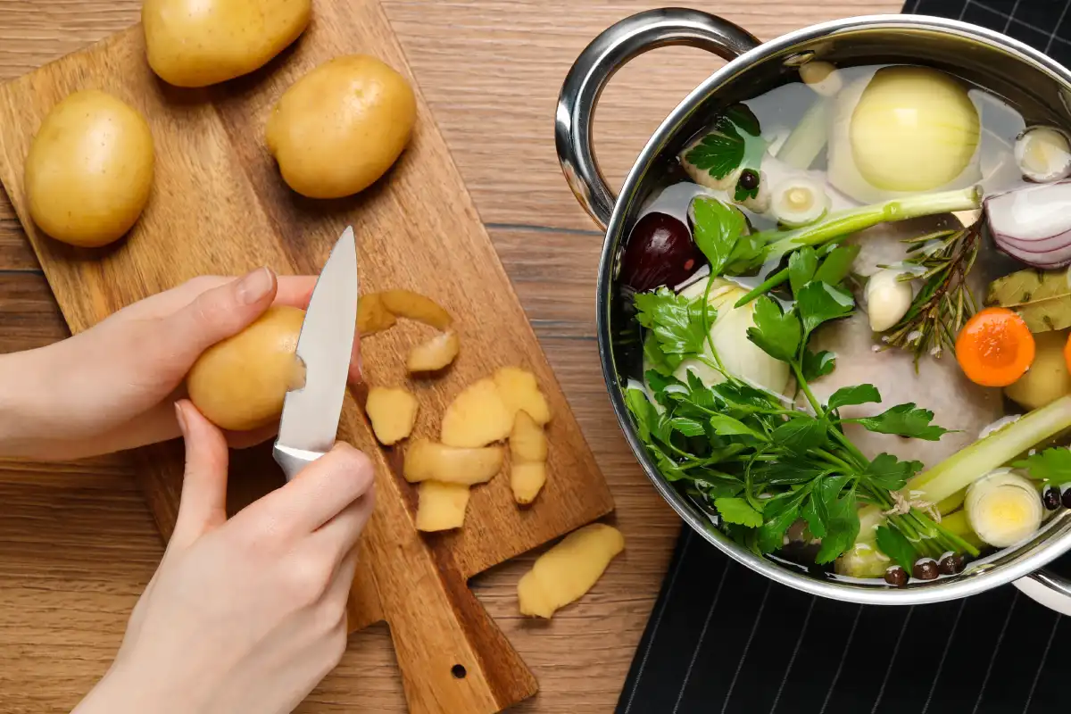 Mujer pela papas para un caldo de pollo