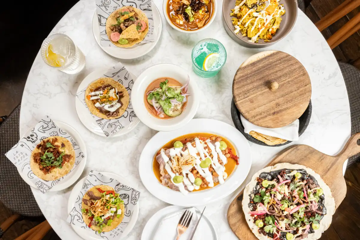 Diversidad de platillos servidos sobre una mesa, desde tacos, tlayudas y sopas