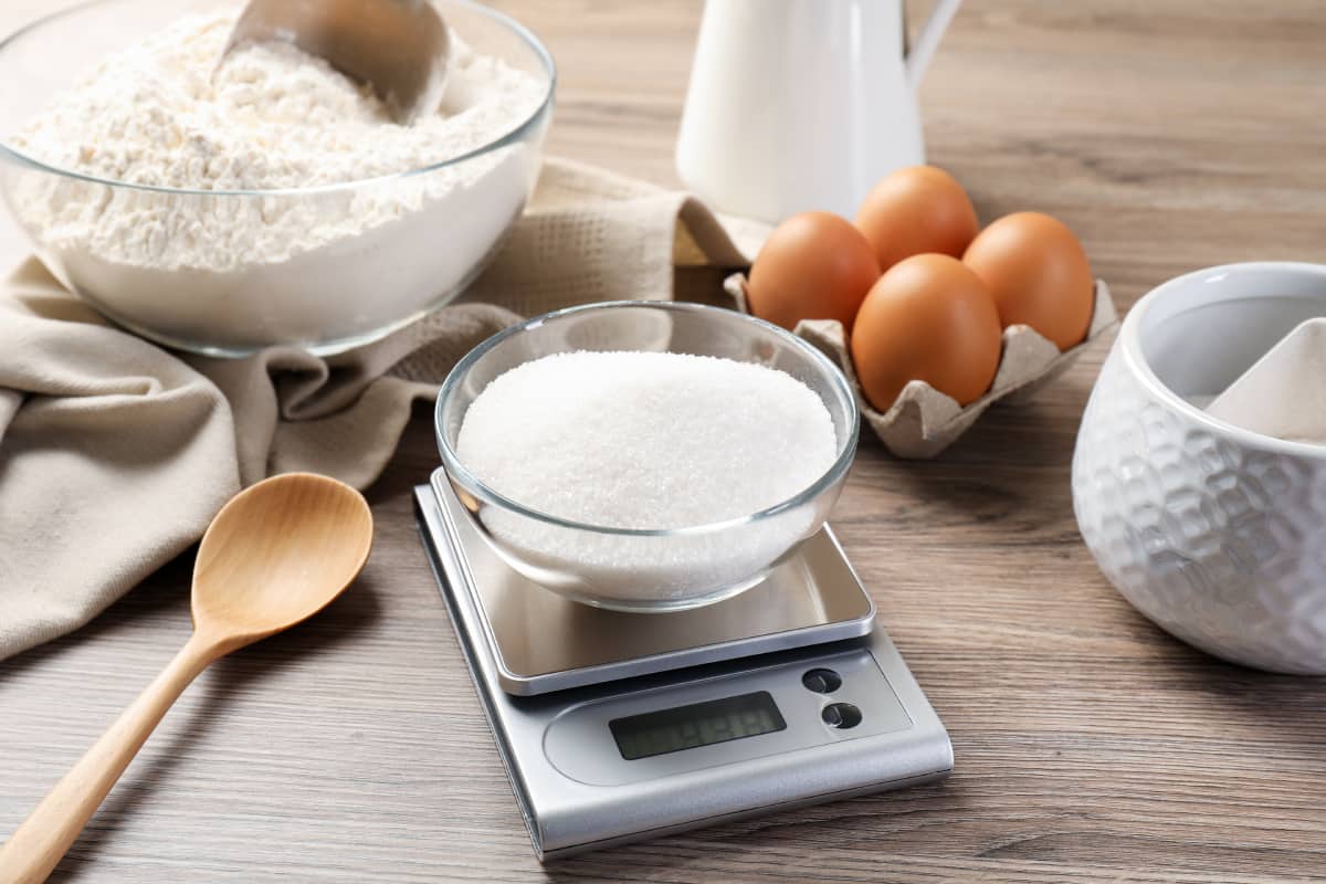 Ingredientes (azúcar, harina y huevo) colocados sobre mesa.