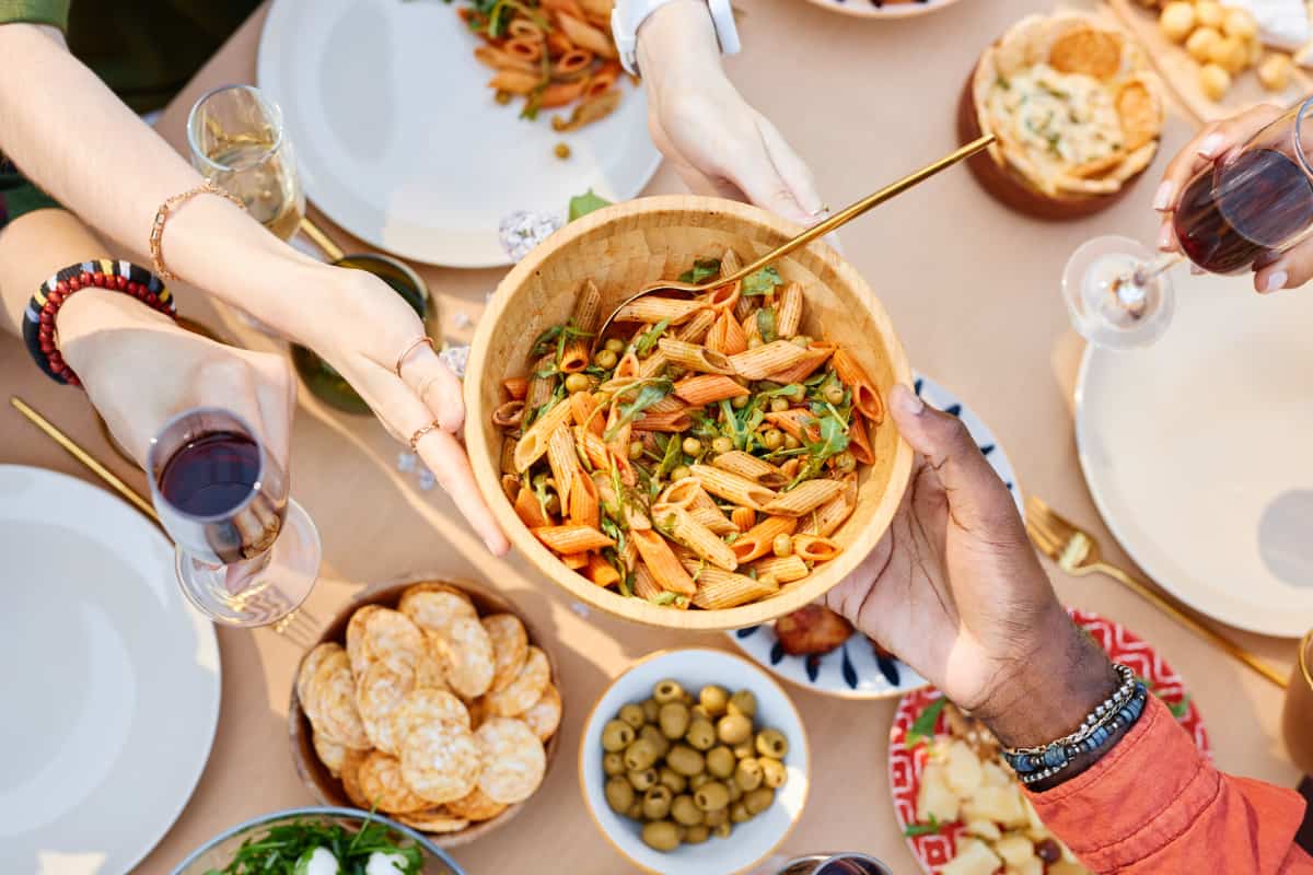 Personas compartiendo platillos en reunión.