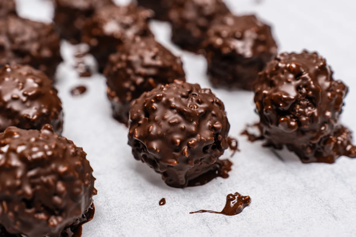 Deliciosas bolas dulces caseras con chocolate servidas en una servilleta blanca.