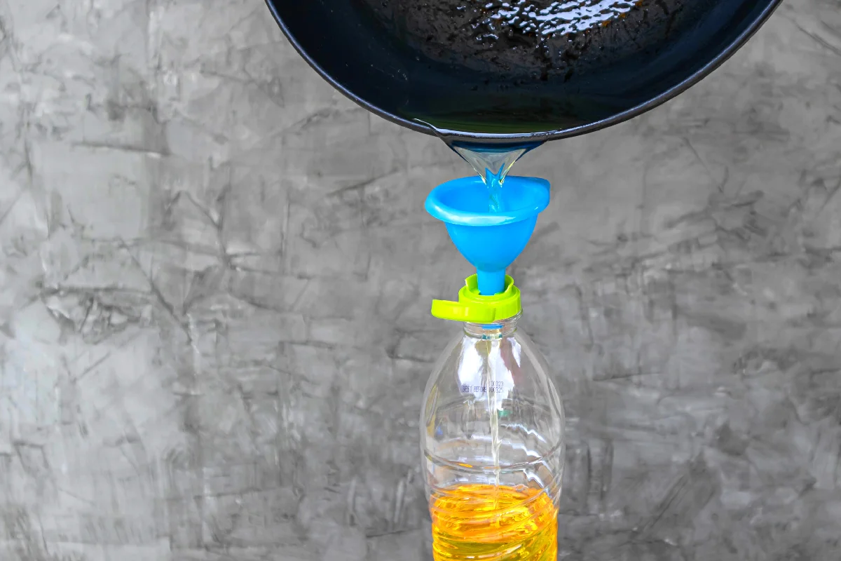 Vierta el aceite de cocina usado de la sartén en una botella de plástico.