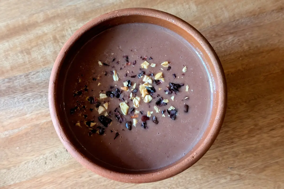 Atole de frijol servido en una taza de barro