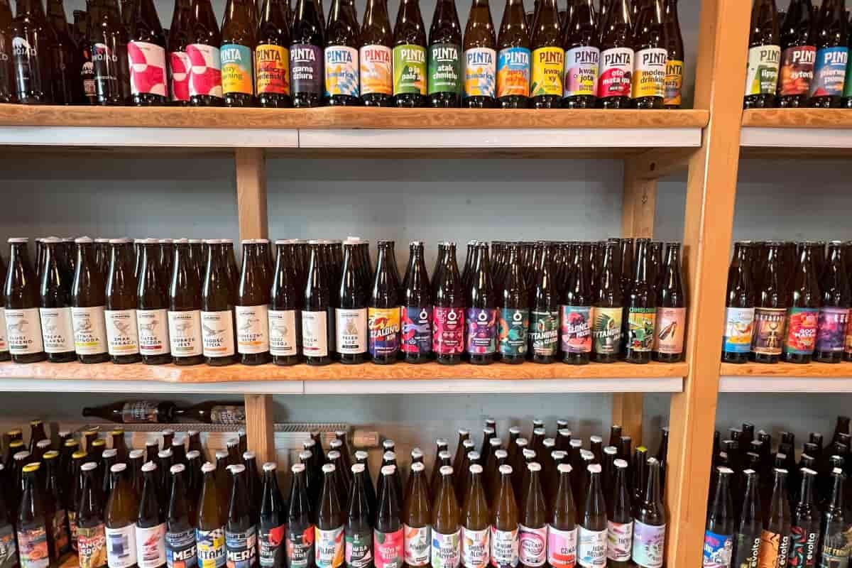 Variedad de botellas de bebidas artesanales en estante.