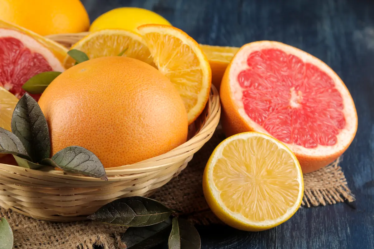 Toronjas y naranjas cortadas por la mitad sobre una canasta