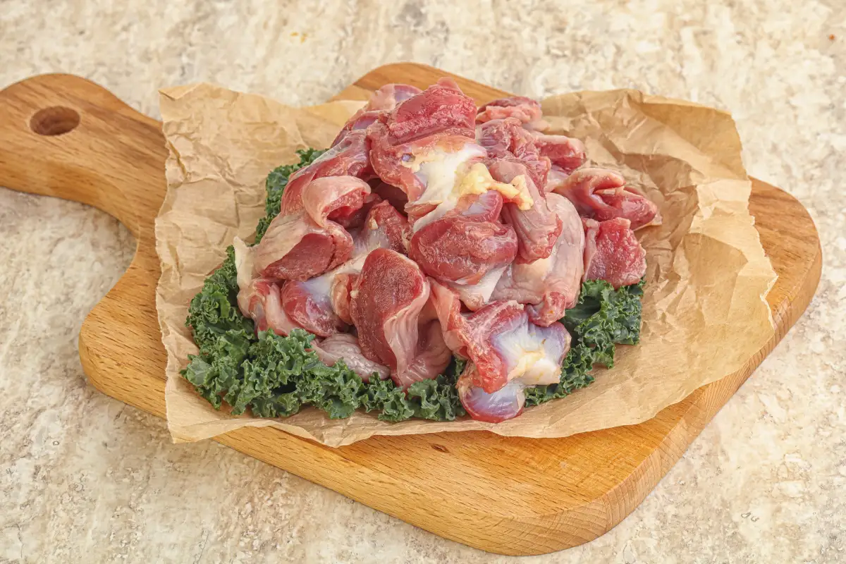 Mollejas de pollo crudas sobre una tabla de madera