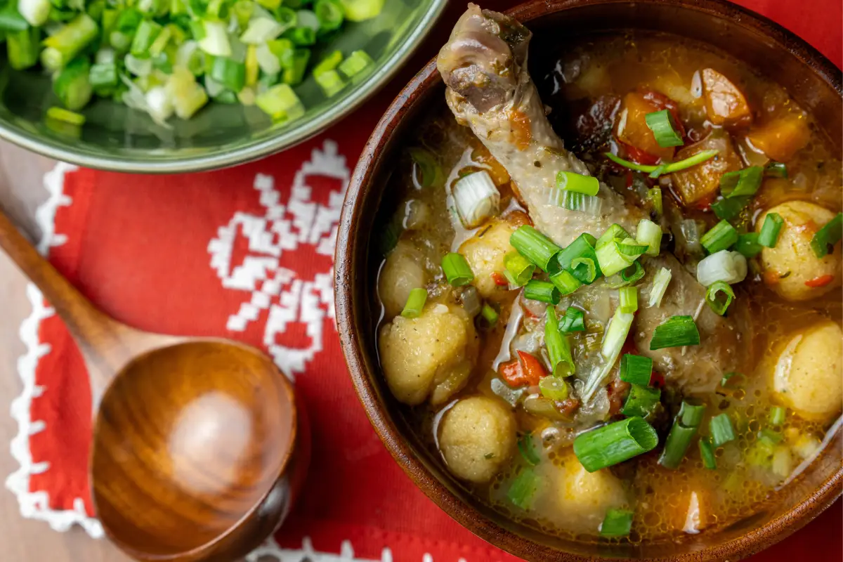 Auténtica sopa Vori Vori con pollo, bolas vori vori y verduras en un rústico tazón de madera, exhibido en un vibrante encaje rojo hecho a mano