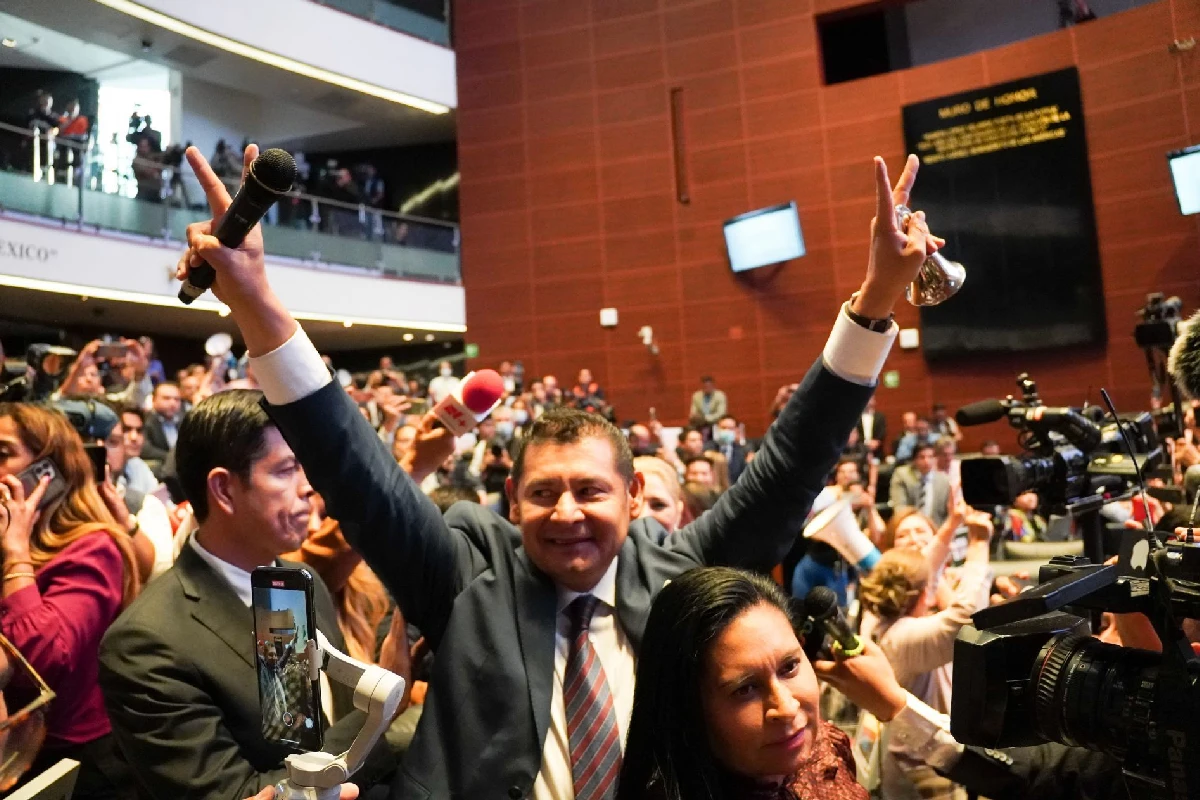 Alejandro armanta con los brazos estirados al aire en modo de celebración 