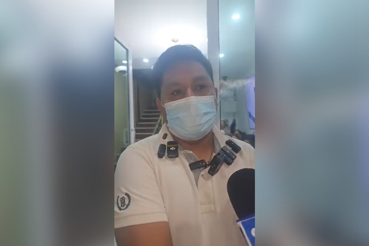 Esposo de mujer que murió tras su cesárea con cubrebocas azul, camisa polo y alrededor de 10 micrófonos en su cuello