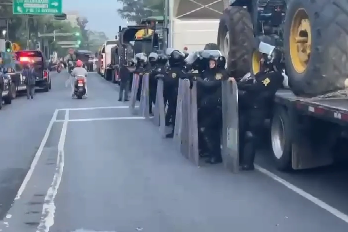 Policías rodeando camiones de transportistas y campesinos