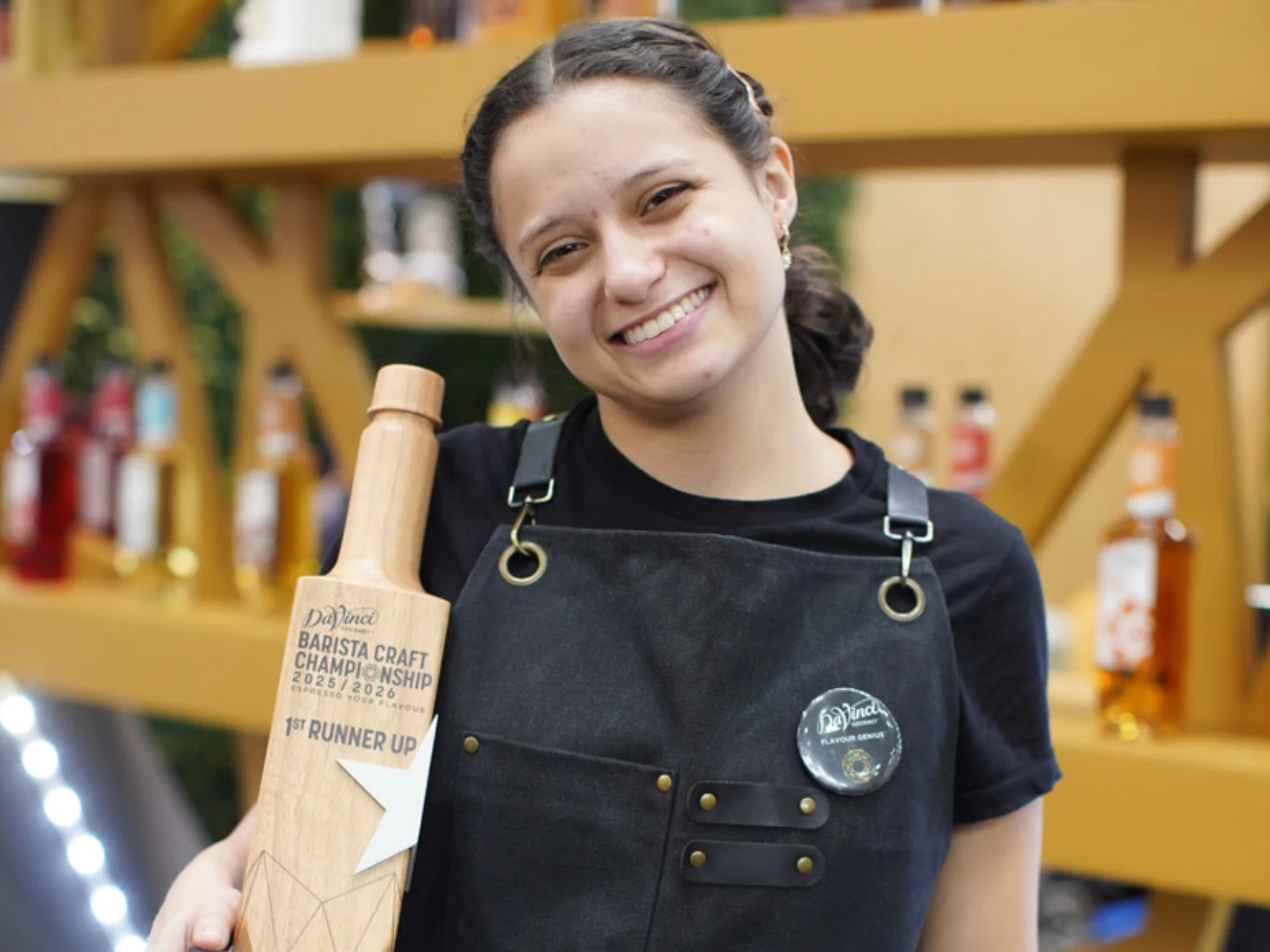 Mujer sonriente sostiene trofeo en forma de botella