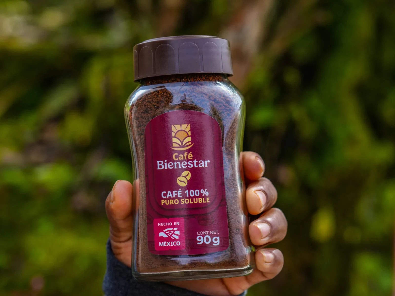 Una mano sostiene un frasco de café soluble 