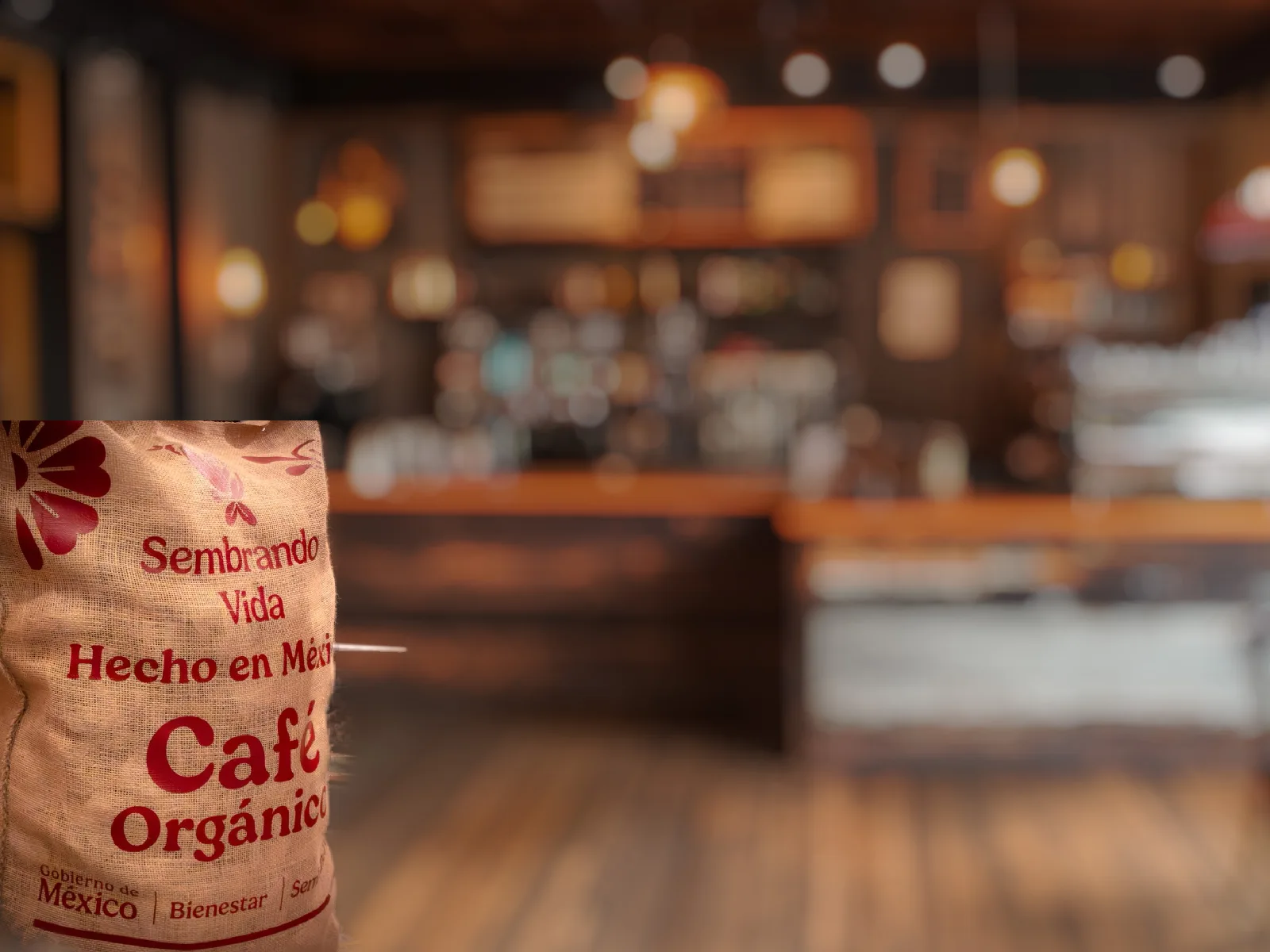 Costal de granos de café mexicano en un fondo desenfocado que simula una cafetería