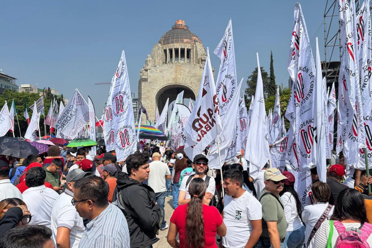 Hay banderas y estandartes entre los asistentes al monumento a la Revolución. 
