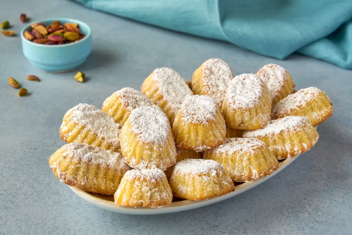 Sobre un plato blanco están servidas galletas espolvoreadas de azúcar glass