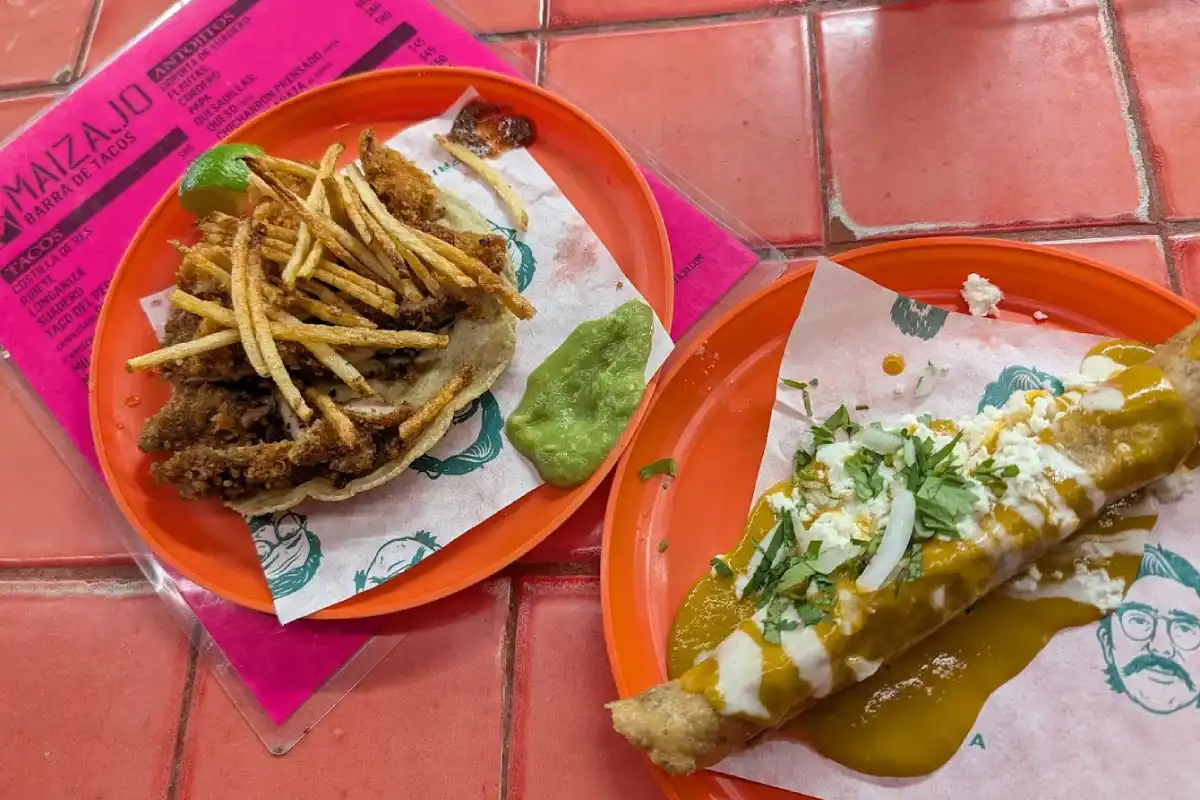 Un taco dorado y taco de bistec servido sobre un plato anaranjado