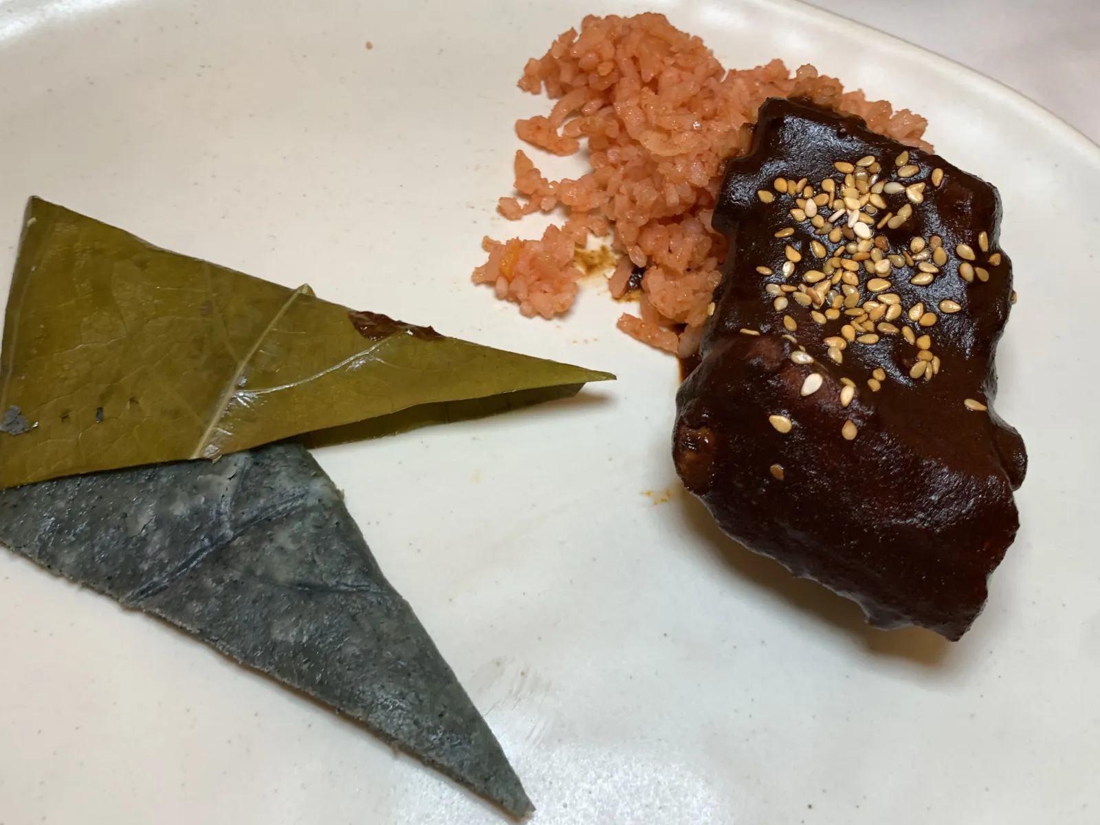 Sobre un plato blanco está servido una costilla de res con mole de Quimixtlán