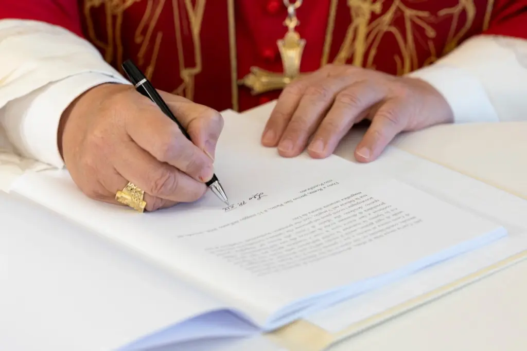 El Papa Leo XIV firma su primera carta encíclica en su libro Magnifica Humanitas.