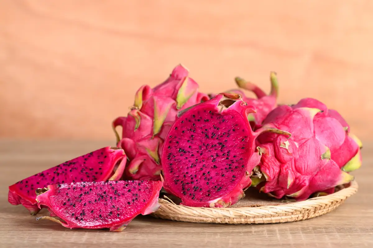 Pitahaya en canasta sobre fondo de madera, fruta tropical en temporada de verano