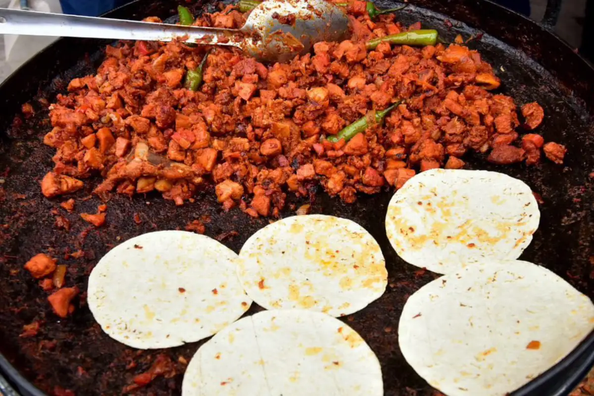 Discada con tortillas de harina sobre una sartén negra