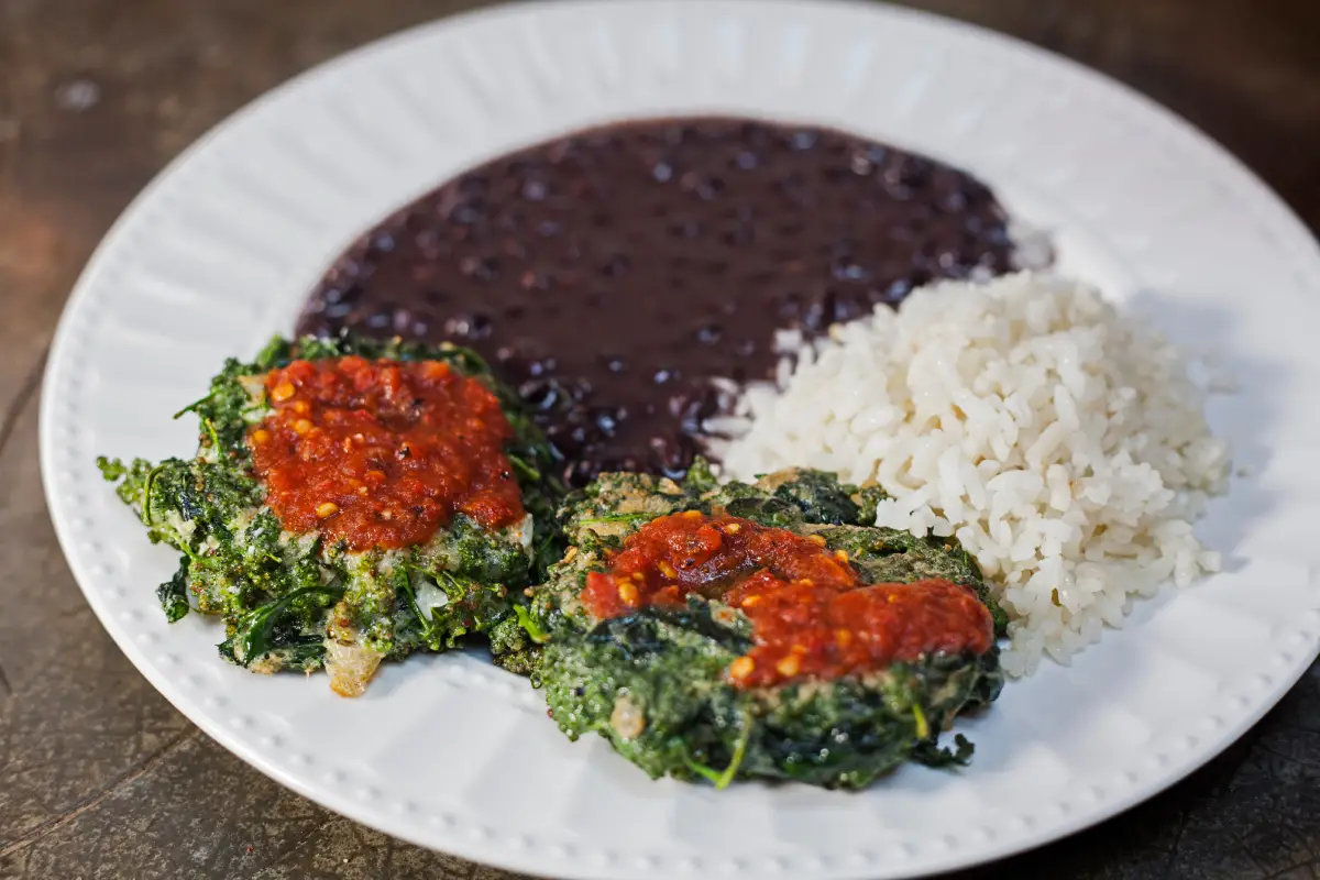 Un plato con dos tortitas de huanzontle acompañadas de arroz blanco y frijol negro