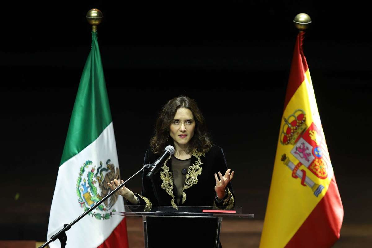 En primer plano Isabel Díaz Ayuso con la bandera de México del lado izquiero y la de España del lado derecho