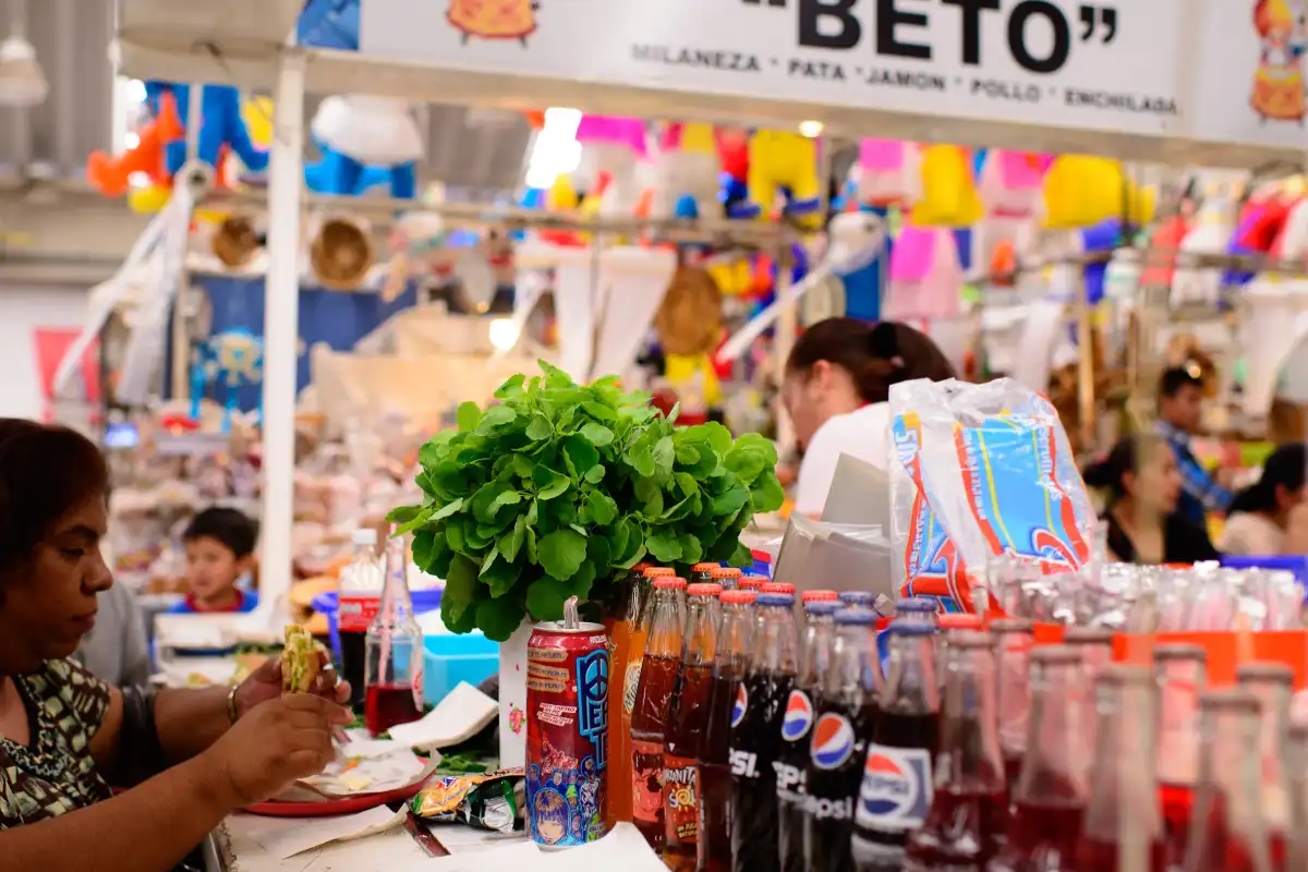 Una personas come sobre un puesto de comida interior de un mercado