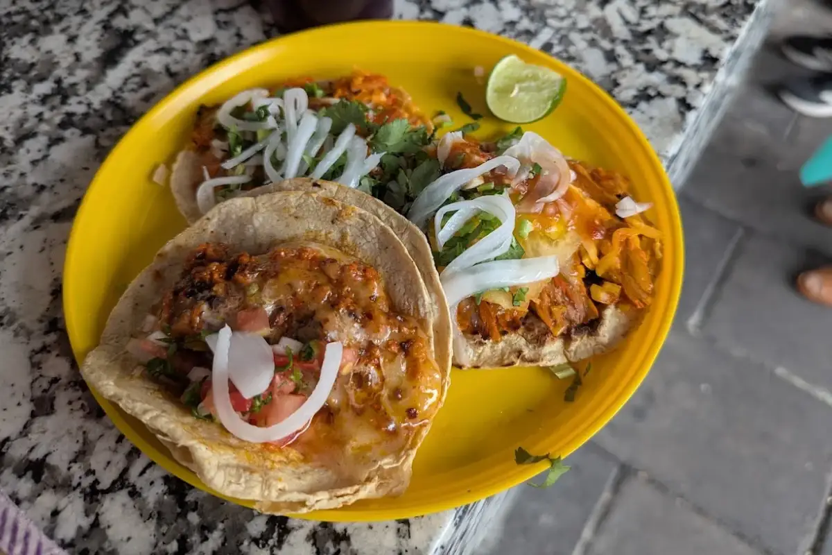Tacos al pastor servido sobre un plato amarillo