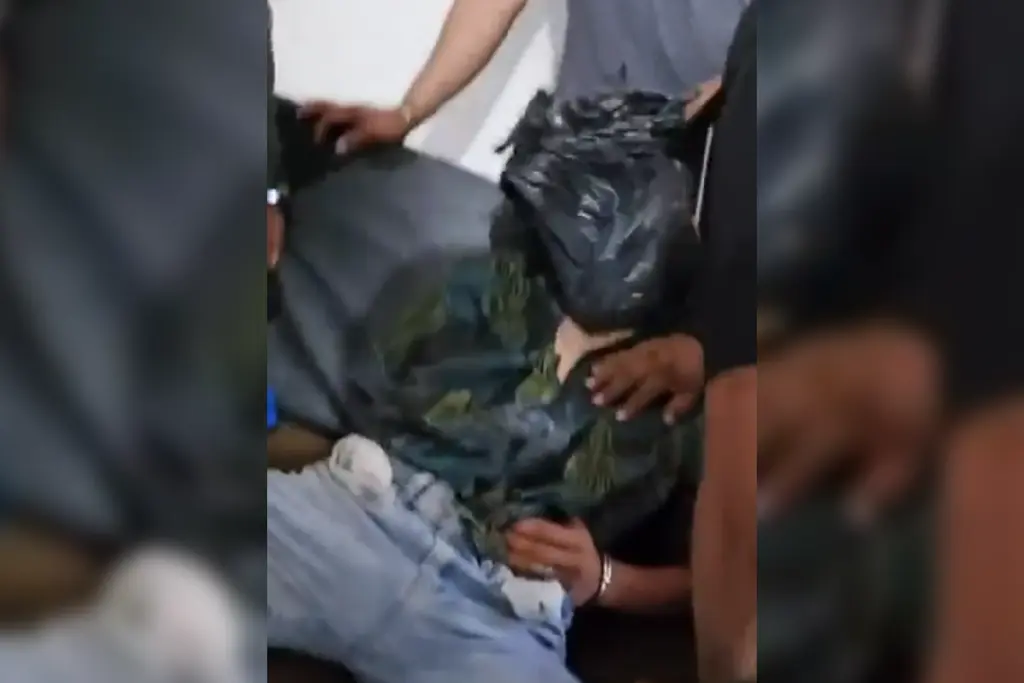 Momento en el que agentes de policía torturan a un hombre colocándole una bolsa negra en la cabeza