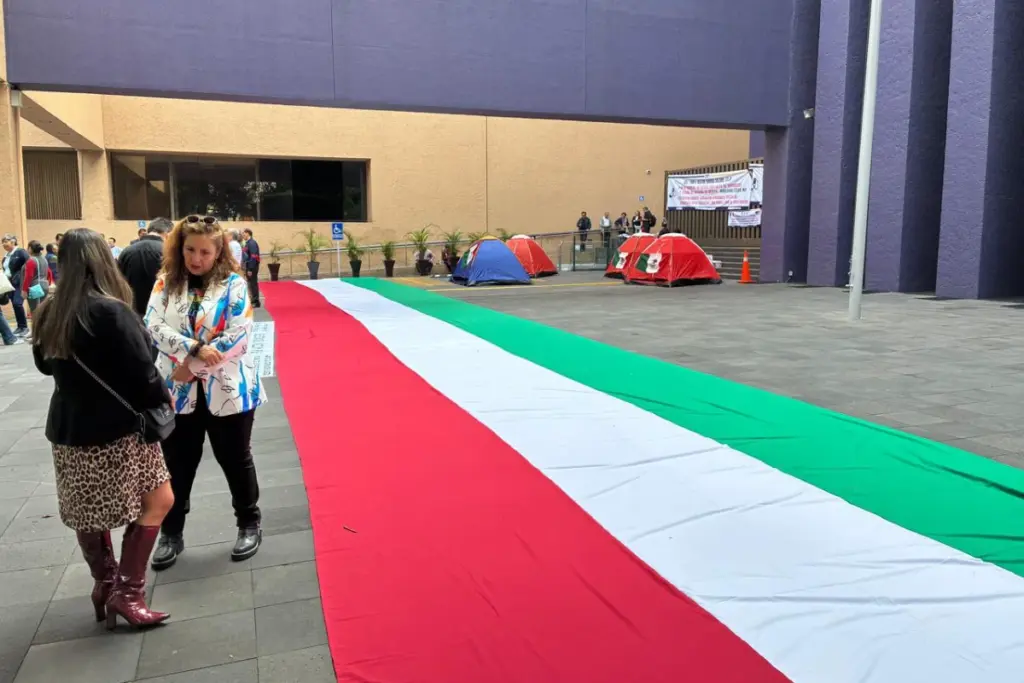 Trabajadores y magistrados esperando fuera de las oficinas mientras las protestas continúan.