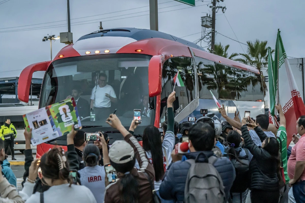 Un camión de pasajeros rodeado por aficionados