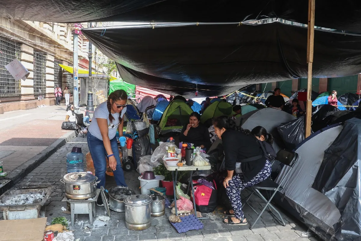 Personas debajo de una loca con casas de campaña cocinando