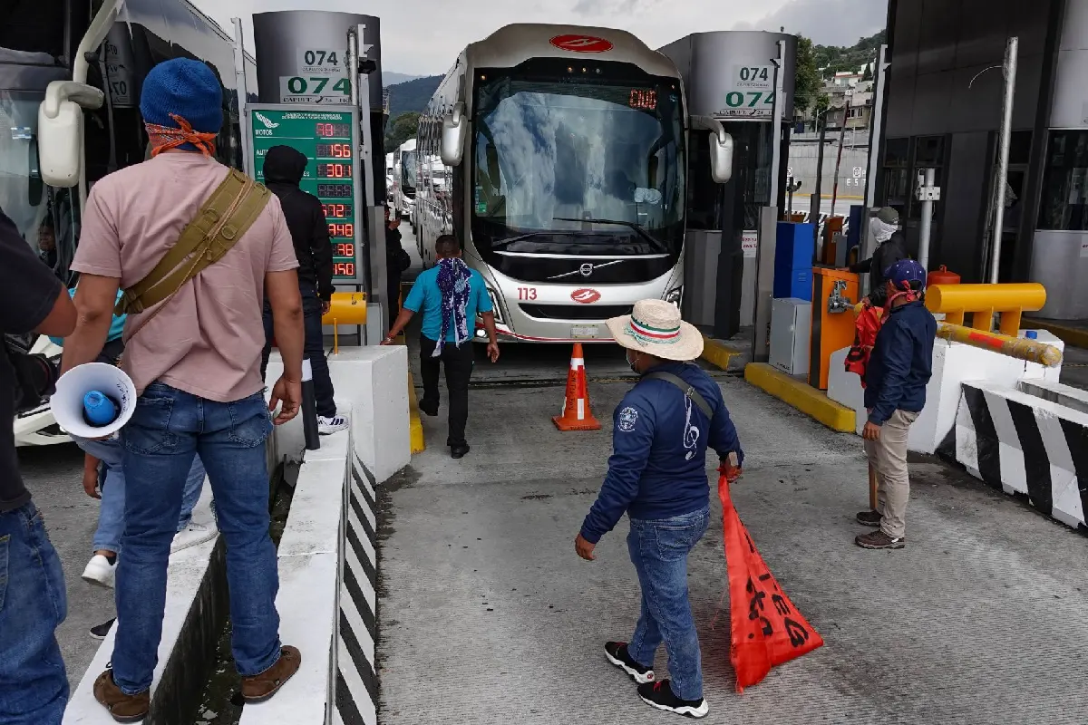 Integrantes de la CNTE en una casta permitiendo el paso a un camión de pasajeros