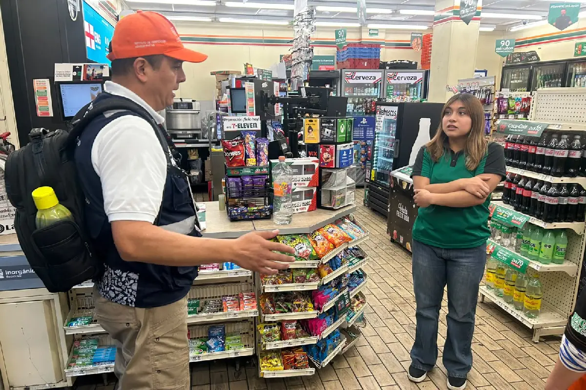 Personal del invea hablando con una trabajadora de una tienda de autoservicio