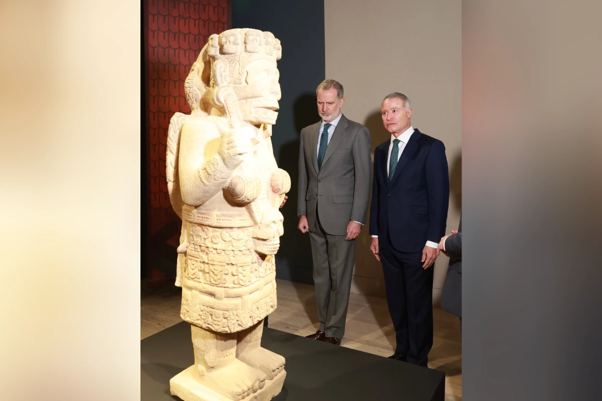 rey de españa observando una escultura indígena