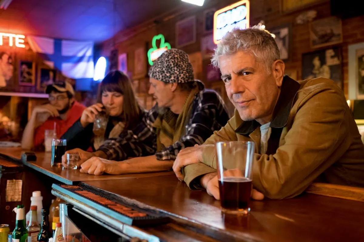 Anthony Bourdain toma cerveza en bar 