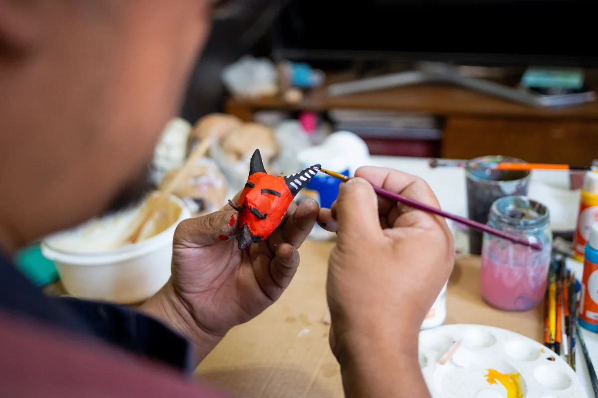 Artesano mexicano pintando alebrijes