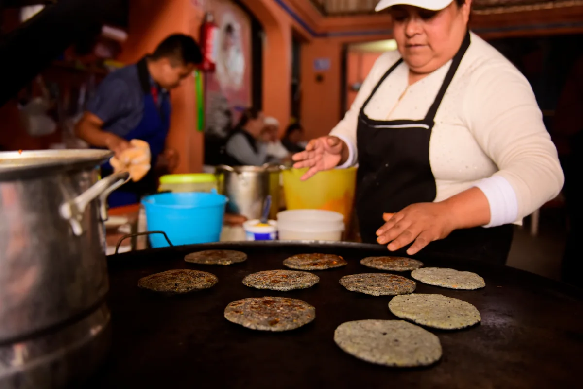 Mujer prepara gorditas en un comal