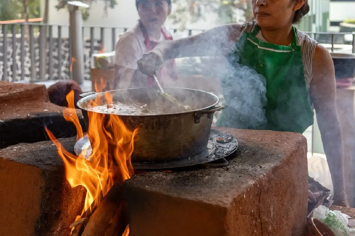 Mujer mueve el guiso al interior de una olla