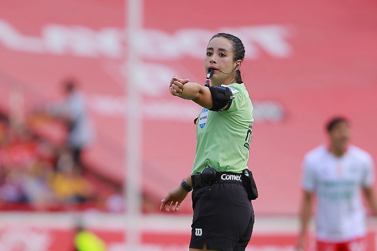 Katia Itzel con uniforme verde arbitrando un juego