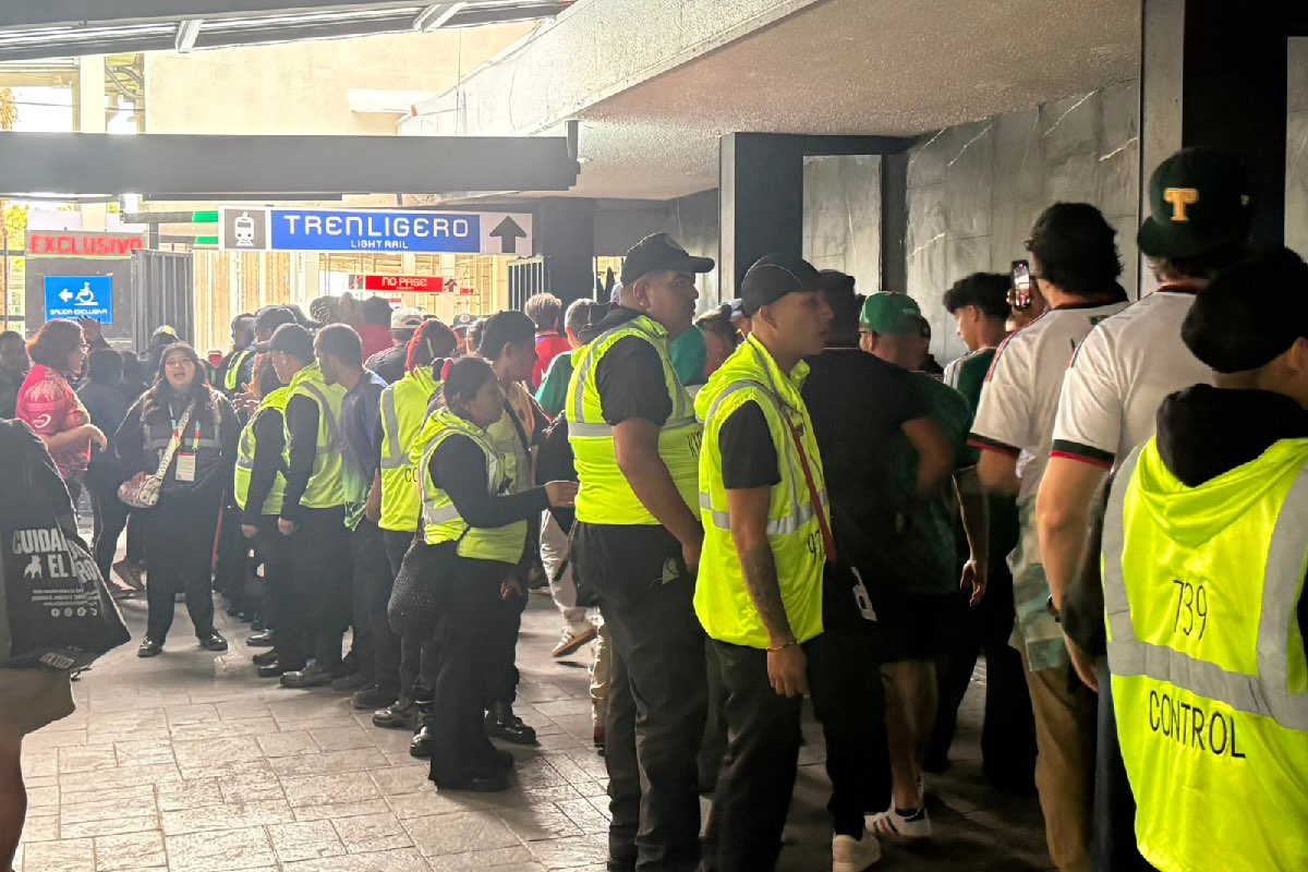 Decenas de policías contenían a la gente que bajaba del Metro en Tasqueña para abordar el Tren rumbo al Estadio Ciudad de México