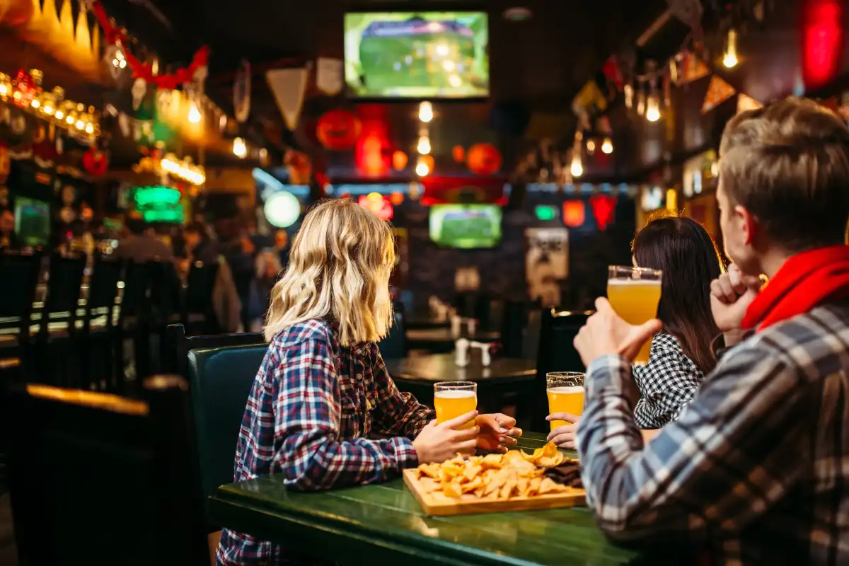 Grupo de amigos viendo un partido de futbol en un bar