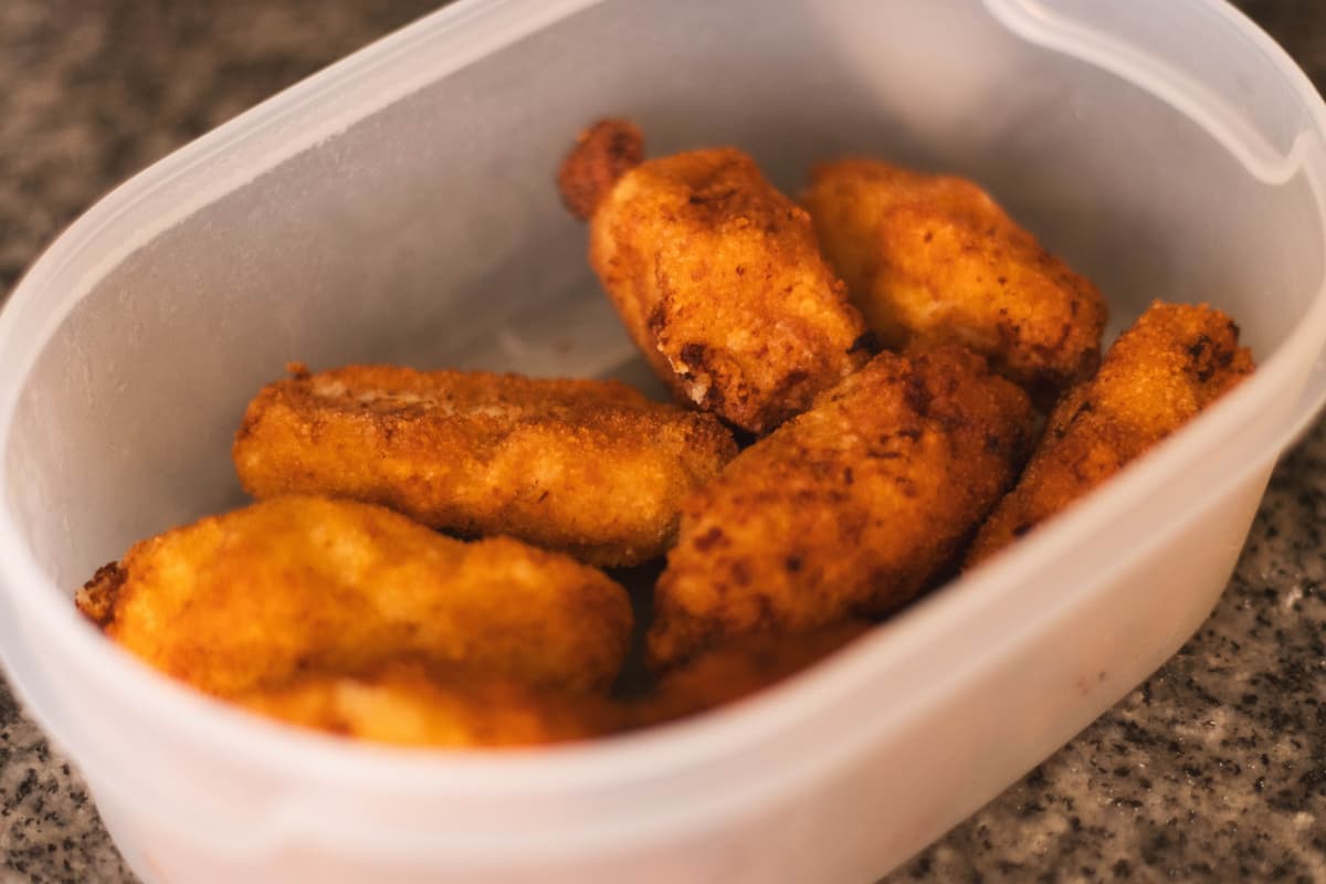 Recipiente de plástico con pollo empanizado 