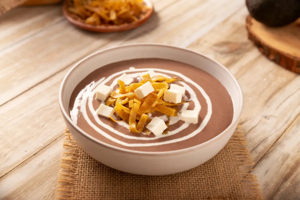 Crema de Frijoles, una receta de comida casera muy fácil y nutritiva, comúnmente acompañada con queso, crema, aguacate y tortilla de maíz cortados en tiras y fritos.
