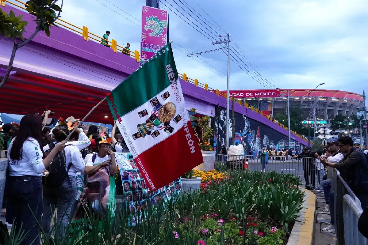 Personas celebrando en el estadio ciudad de méxico con la bandera del país