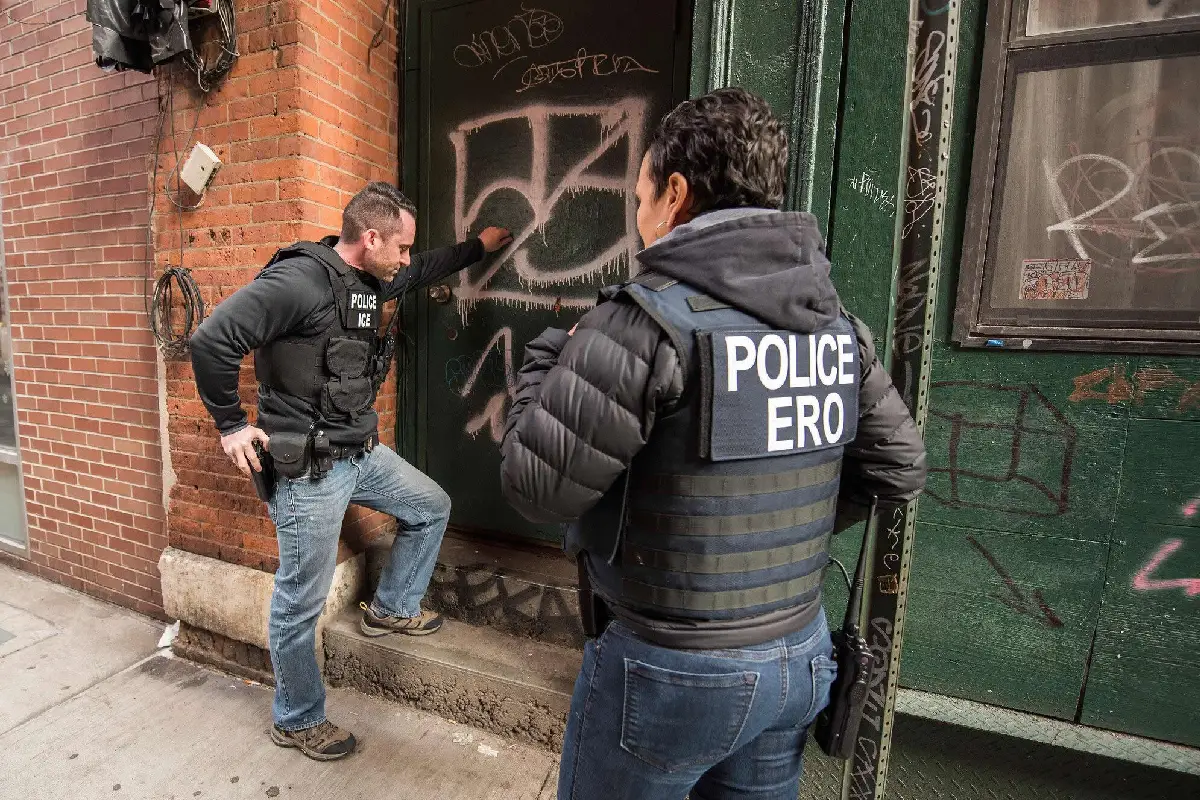Agentes de ICE al exterior de una puerta 