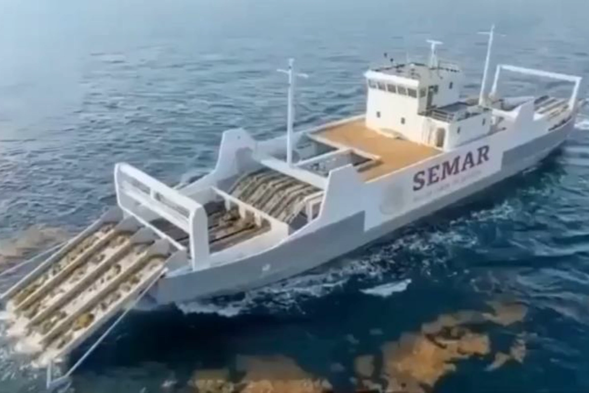 Buque sargacero de la Secretaría de Marina (SEMAR) navegando en mar abierto mientras recolecta sargazo con su sistema de bandas transportadoras.
