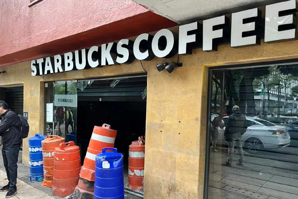 Cafetería con trafitambos bloqueando la entrada de cristal roto 