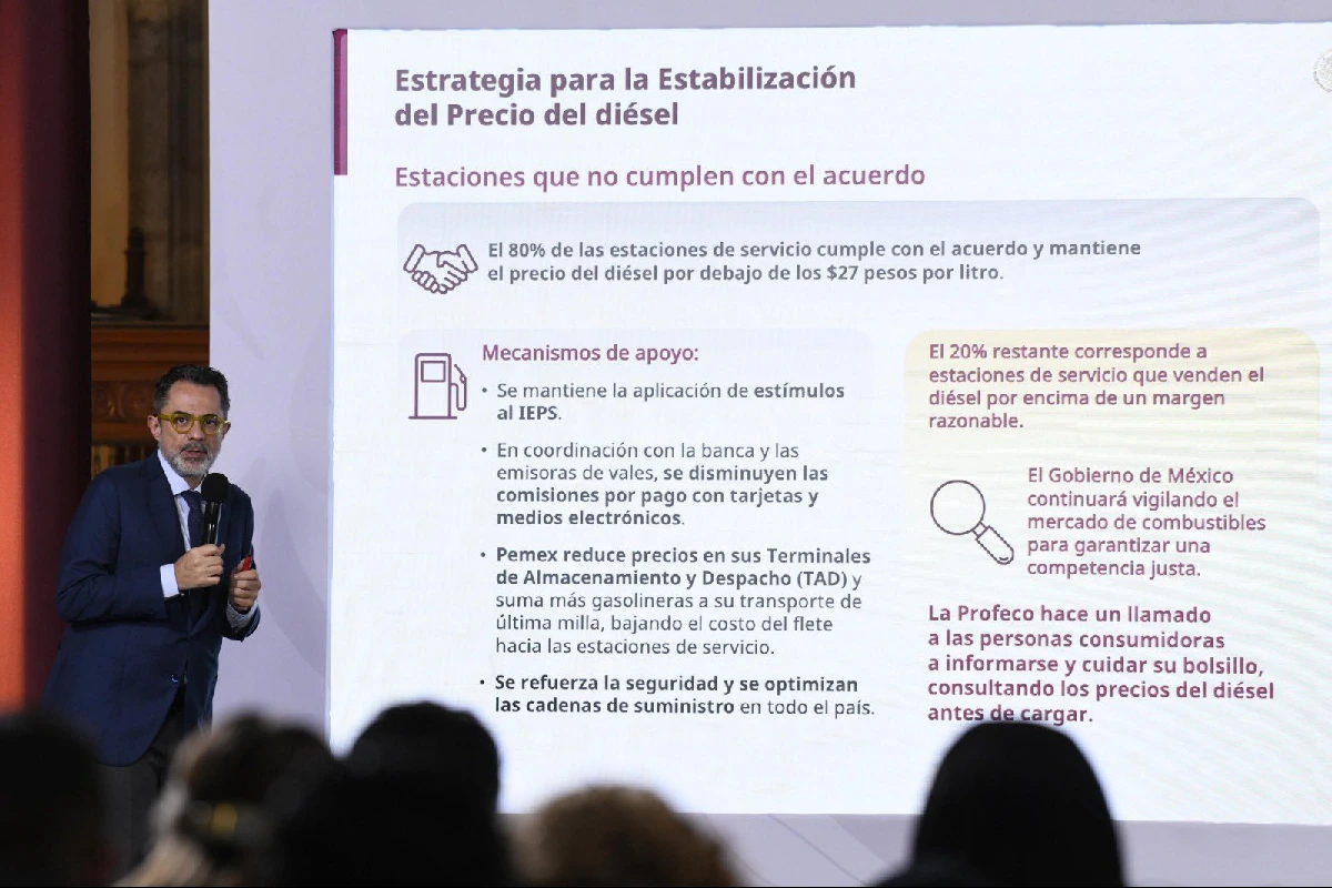 Iván Escalante presentando en la conferencia de prensa matutina a un costado de la pantalla gigante 