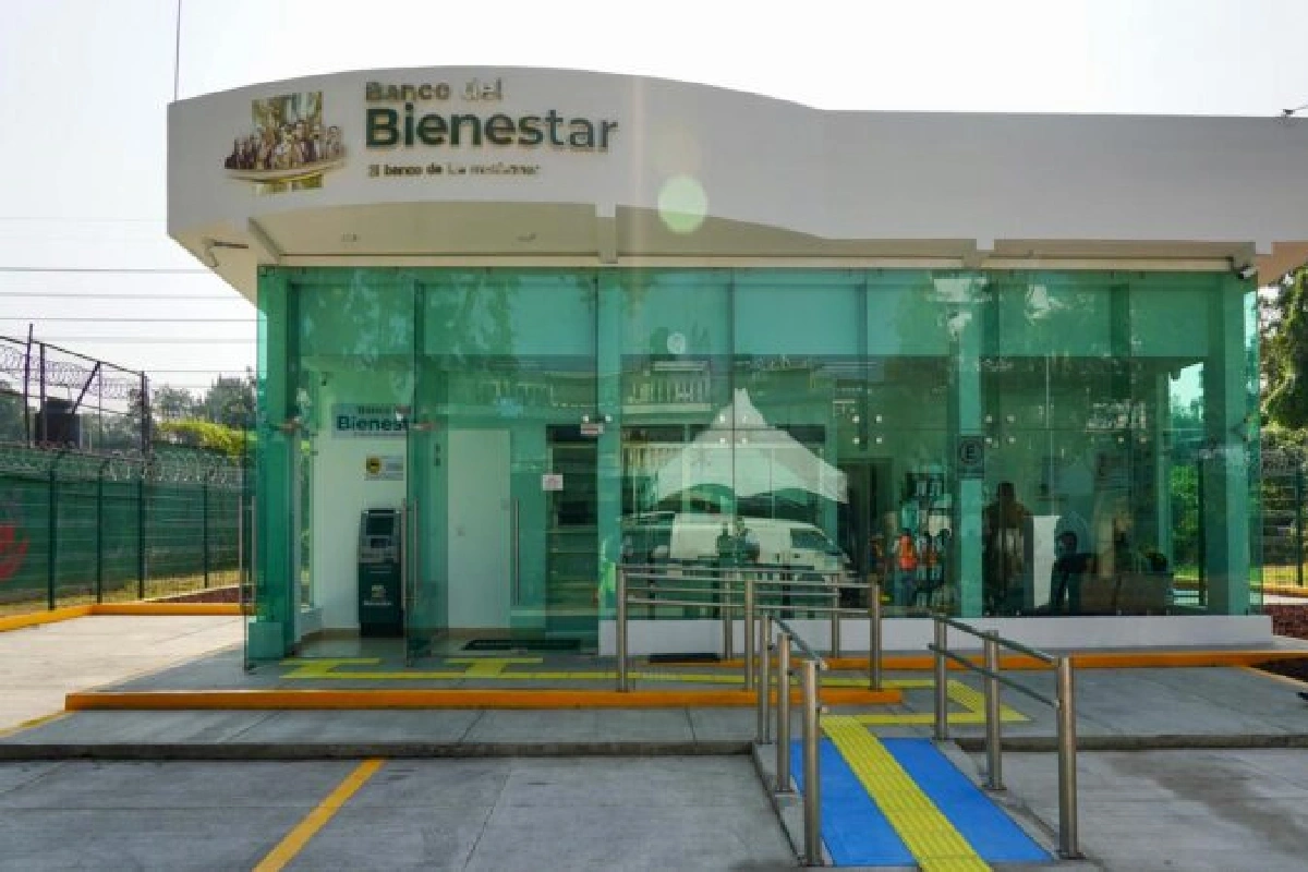 Fachada de un banco del Bienestar con sus cristales verdes y un techo con el logo del banco 